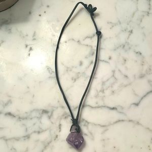 Raw amethyst gemstone necklace attached with adjustable leather cord